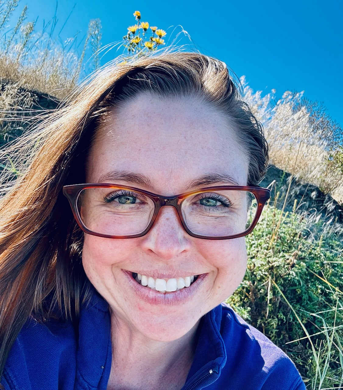 Anna smiling at the camera outdoors